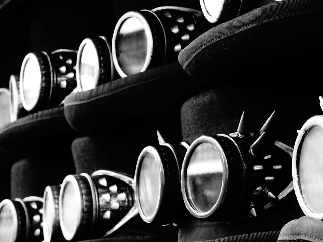 Black and white image of steampunk goggles with spikes, showcasing industrial design.